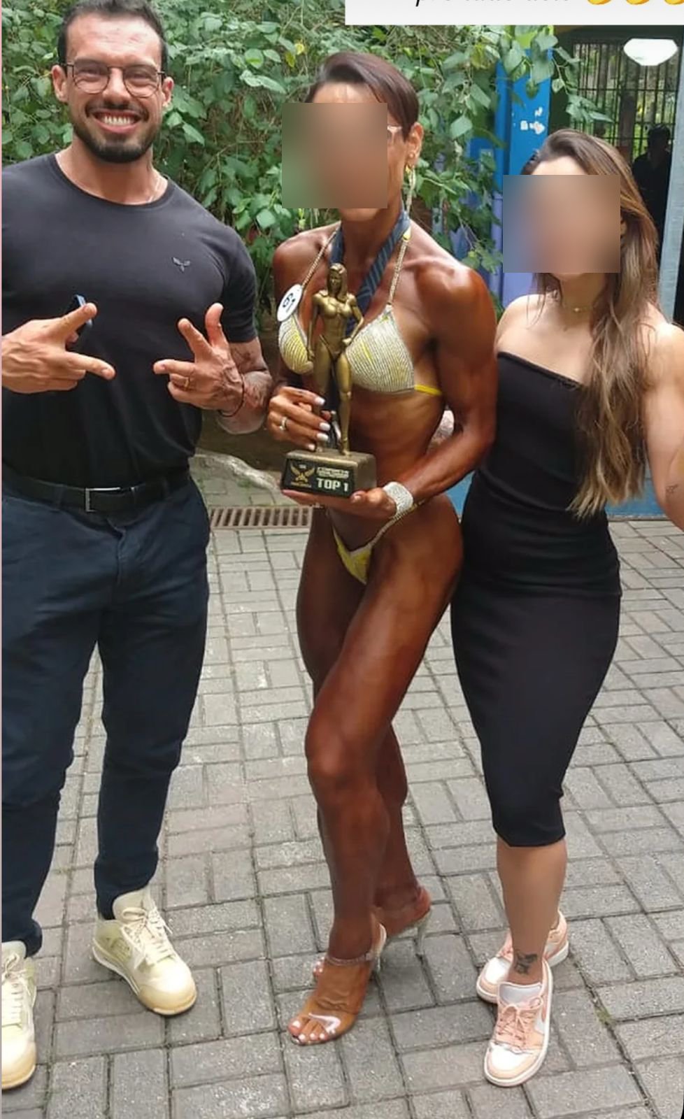 Aluna campeã de fisiculturismo com troféu ao lado de André Pacioni